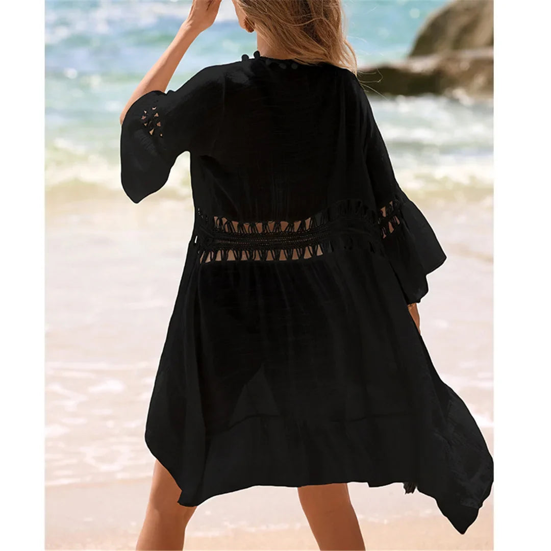 Tunique de plage crochet noire vue de dos, bandes en crochet ajourées et manches évasées sur la plage