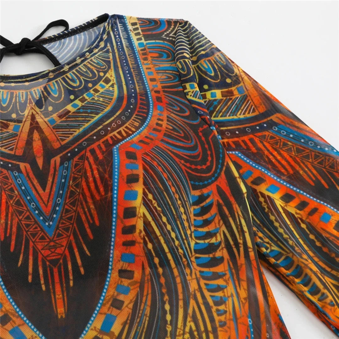 Gros plan sur le haut manches longues bleu à motifs orange du maillot de bain, tissu transparent et lien noué au col