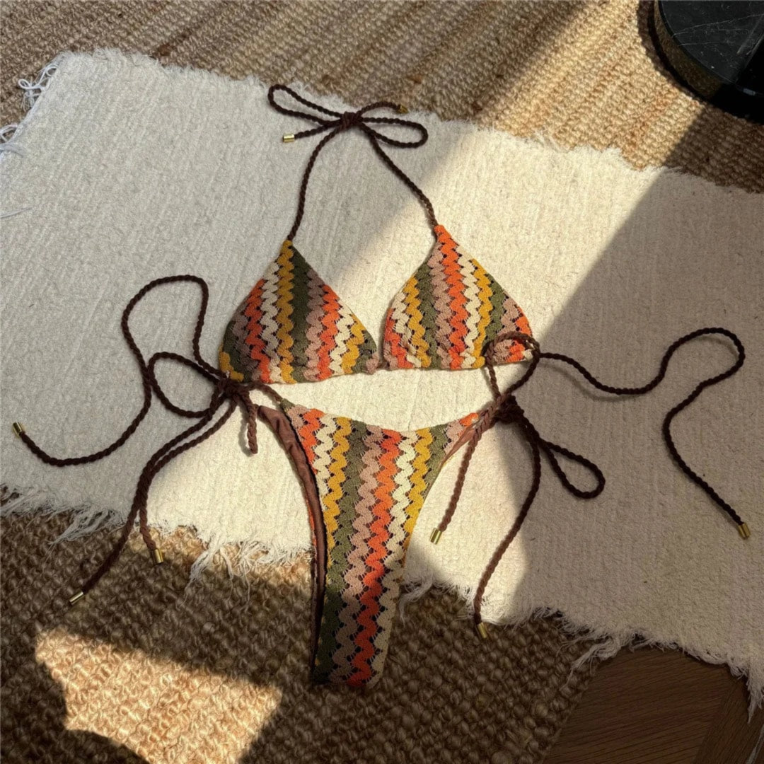 Bikini tour de cou échancré marron en crochet à chevrons multicolores, étalé à plat sur un tapis, cordons bruns tressés