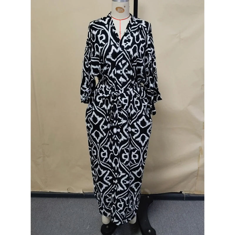 Robe de plage imprimée à manches longues col V noir vue de face sur mannequin, motif noir et blanc, ceinture à la taille