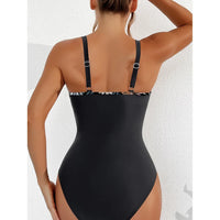 Maillot une pièce noir vu de dos sur une femme, bretelles fines à bordure imprimée feuilles et dos plein