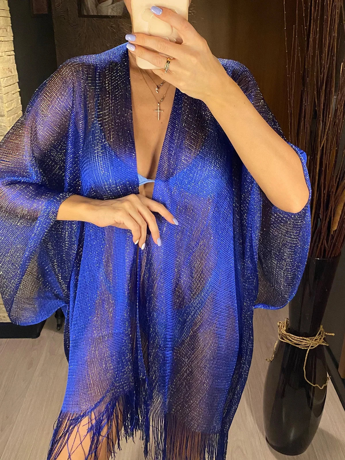Tunique de plage à franges en maille brillante bleue portée de face en selfie miroir, maille ajourée sur un maillot sombre