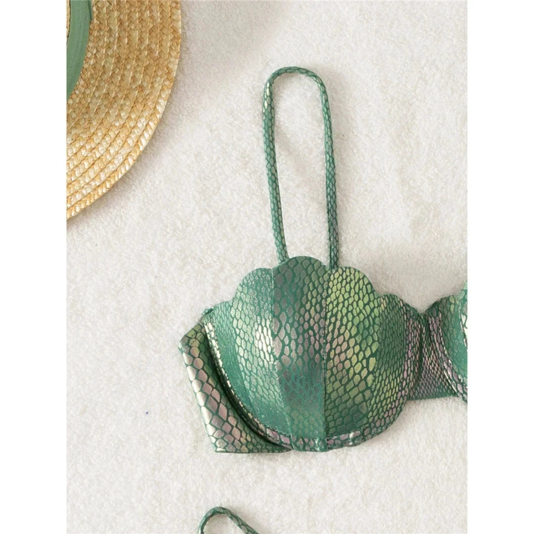 Gros plan sur un bonnet festonné vert effet serpent, bretelles fines et armatures apparentes sous le tissu