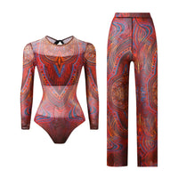 Maillot de bain une pièce manches longues et pantalon rouge brique à motifs ornementaux posé à plat sur fond blanc