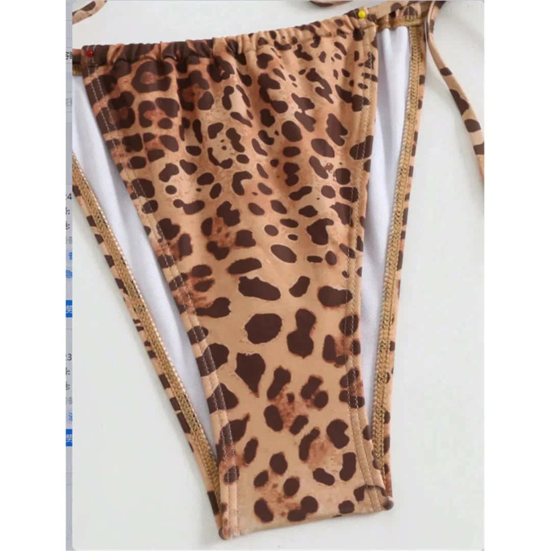 Gros plan sur le slip du maillot de bain imprimé léopard, liens latéraux et bordure fine