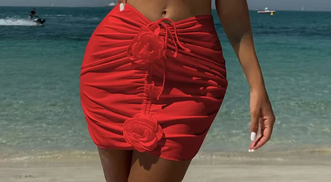Gros plan sur le bas du trikini avec jupe froncée et fleurs en relief rouge