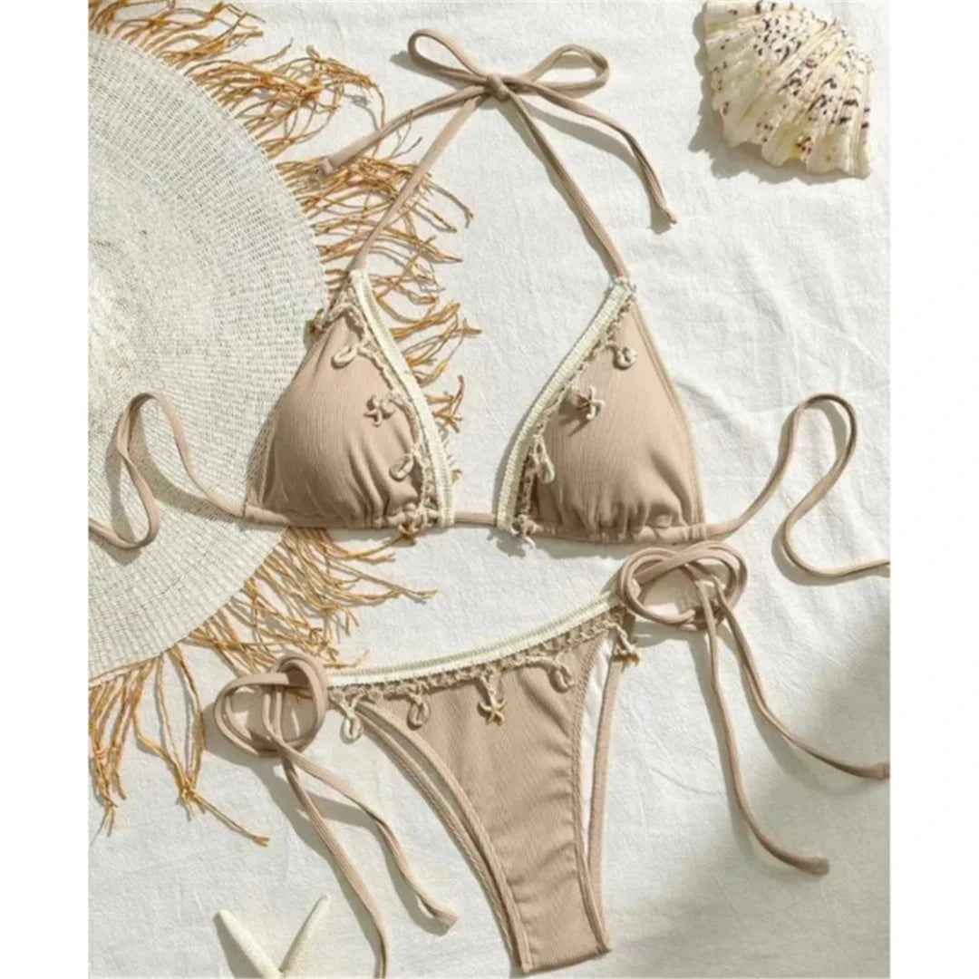 Bikini brésilien tour de cou patchwork à lanières marron clair posé à plat sur fond blanc, bordure crème et breloques