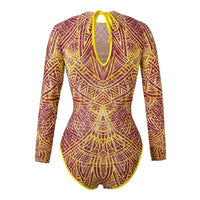 Maillot une pièce jaune et violet à manches longues vu de dos, encolure ouverte avec lien, motifs ornementaux partout