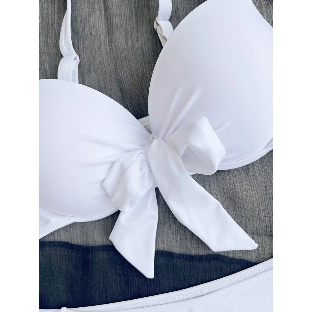 Gros plan sur le nœud central du bonnet blanc, tissu lisse et bretelles fines réglables du bikini push-up noué