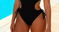 Gros plan sur le bas du maillot une pièce à découpes décolleté plongeant noir