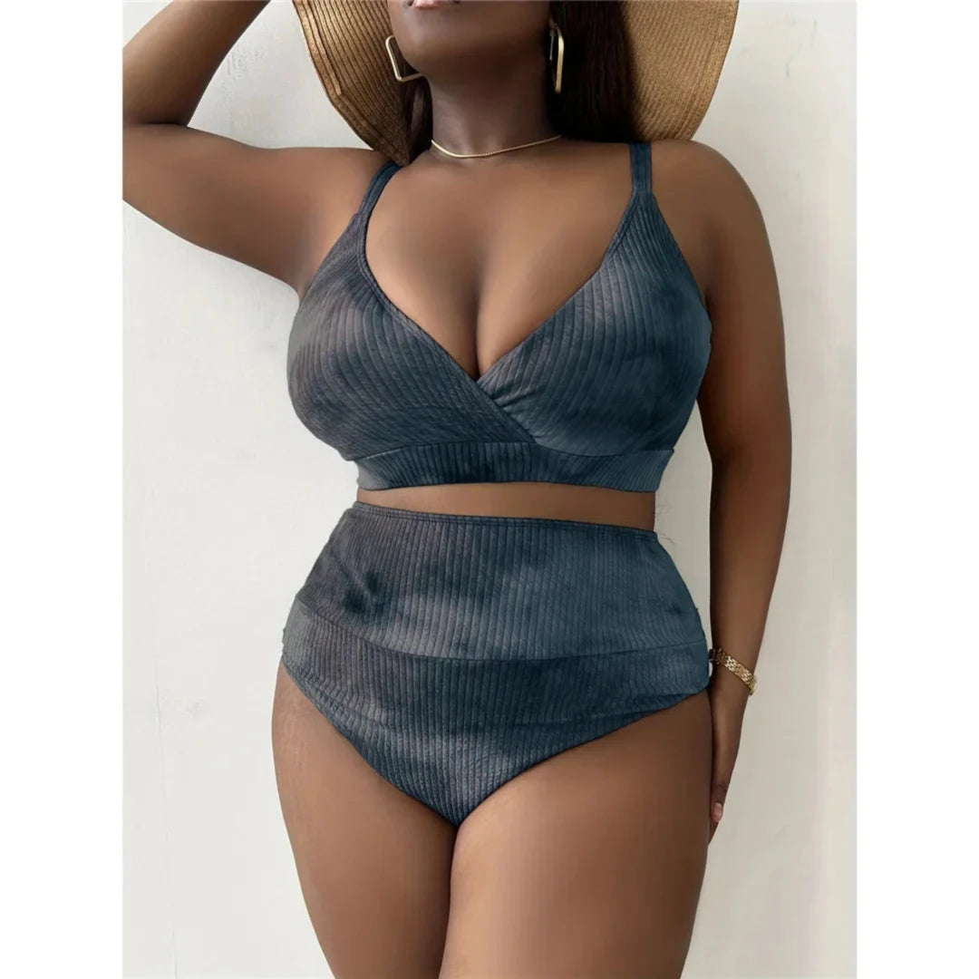 Bikini grande taille noir délavé à taille haute, porté allongé sur un canapé blanc, visage masqué par un cadre clair