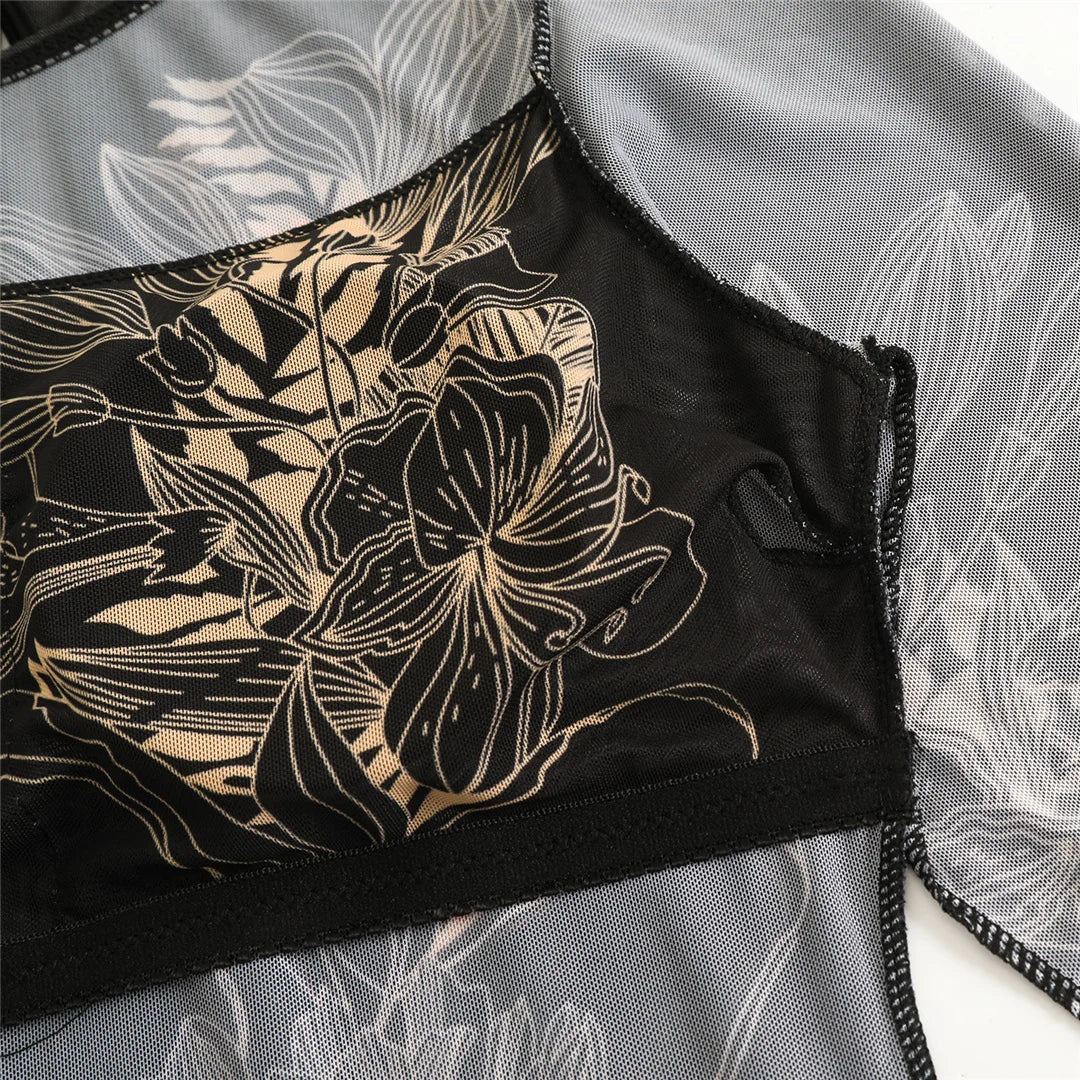 Gros plan sur le buste du body noir en mesh à grandes fleurs dessinées beiges, bande noire et tissu transparent