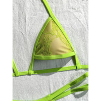 Gros plan sur le triangle en dentelle vert fluo du bikini string micro, bordure verte et fines bretelles