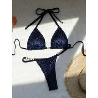 Bikini string triangle sans armatures imprimé léopard bleu posé à plat sur fond blanc, bretelles fines et chapeau de paille
