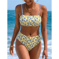 Haut bandeau jaune clair à fleurs bleues et bas taille haute porté de face par une femme souriante, colliers dorés au cou