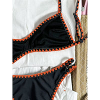 Bikini brésilien triangle imprimé fleuri noir et orange, gros plan sur le triangle du haut et ses fleurs orange