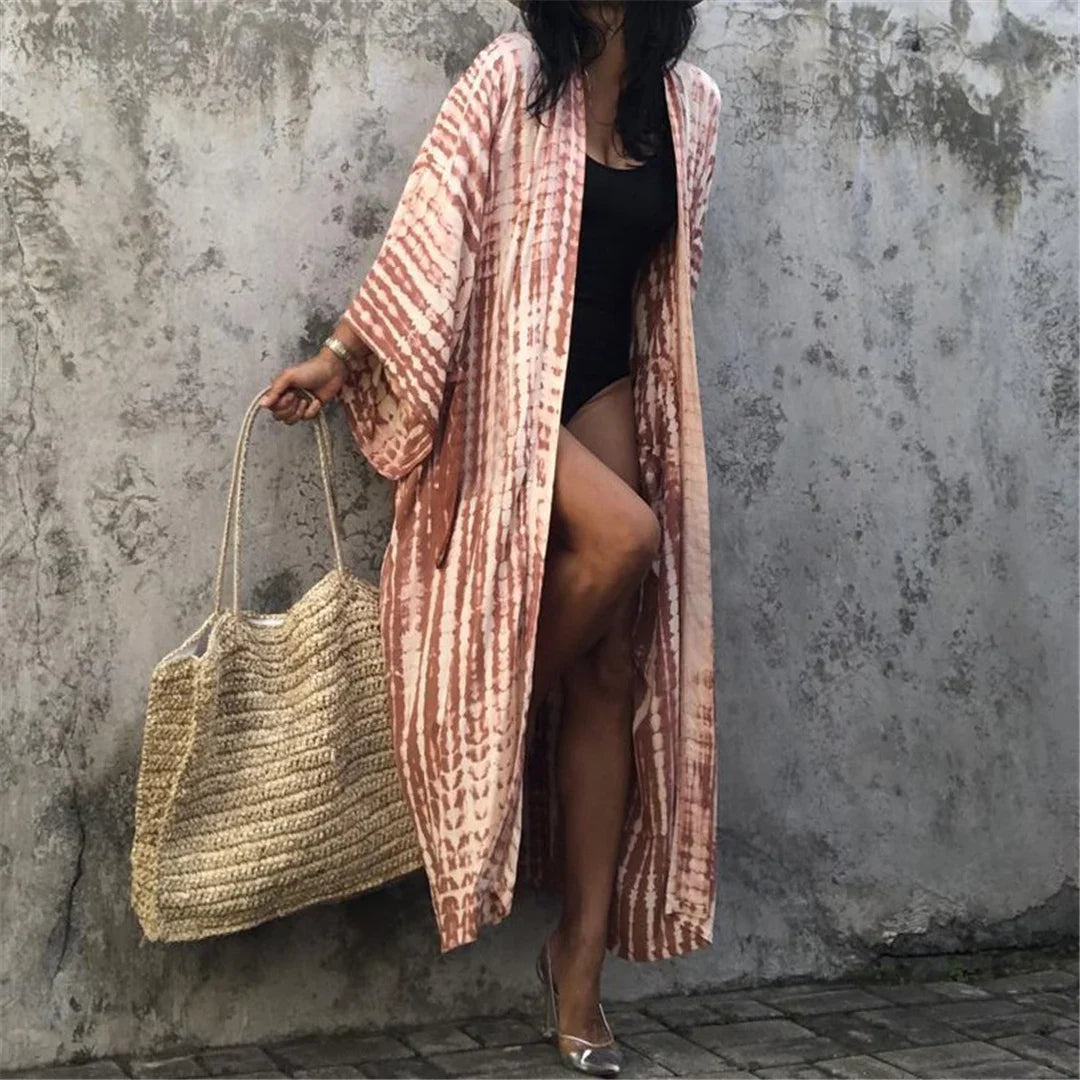 Kimono de plage long tie-dye rouge rouille à ceinture, porté ouvert par une femme sur fond de mur gris