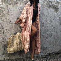 Kimono de plage long tie-dye rouge rouille à ceinture, porté ouvert par une femme sur fond de mur gris
