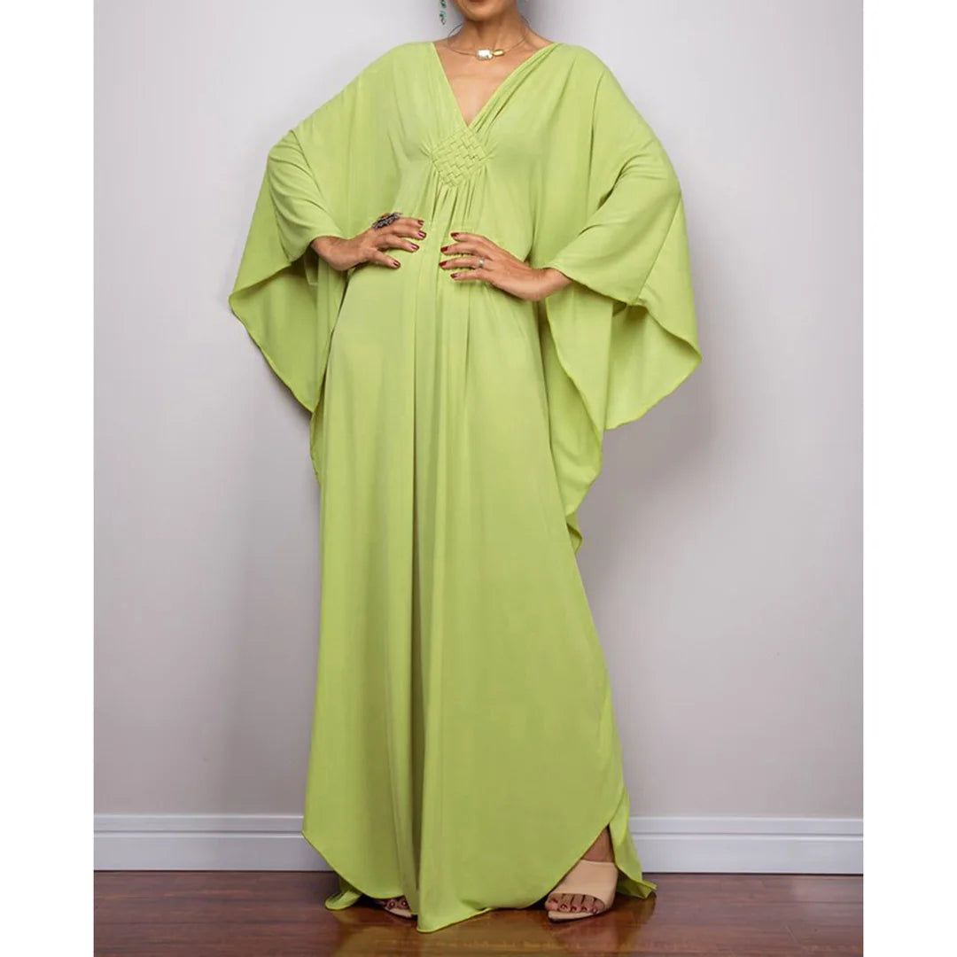 Robe de plage longue kaftan manches chauve-souris vert anis portée de face avec sandales beiges aux pieds, ourlet asymétrique