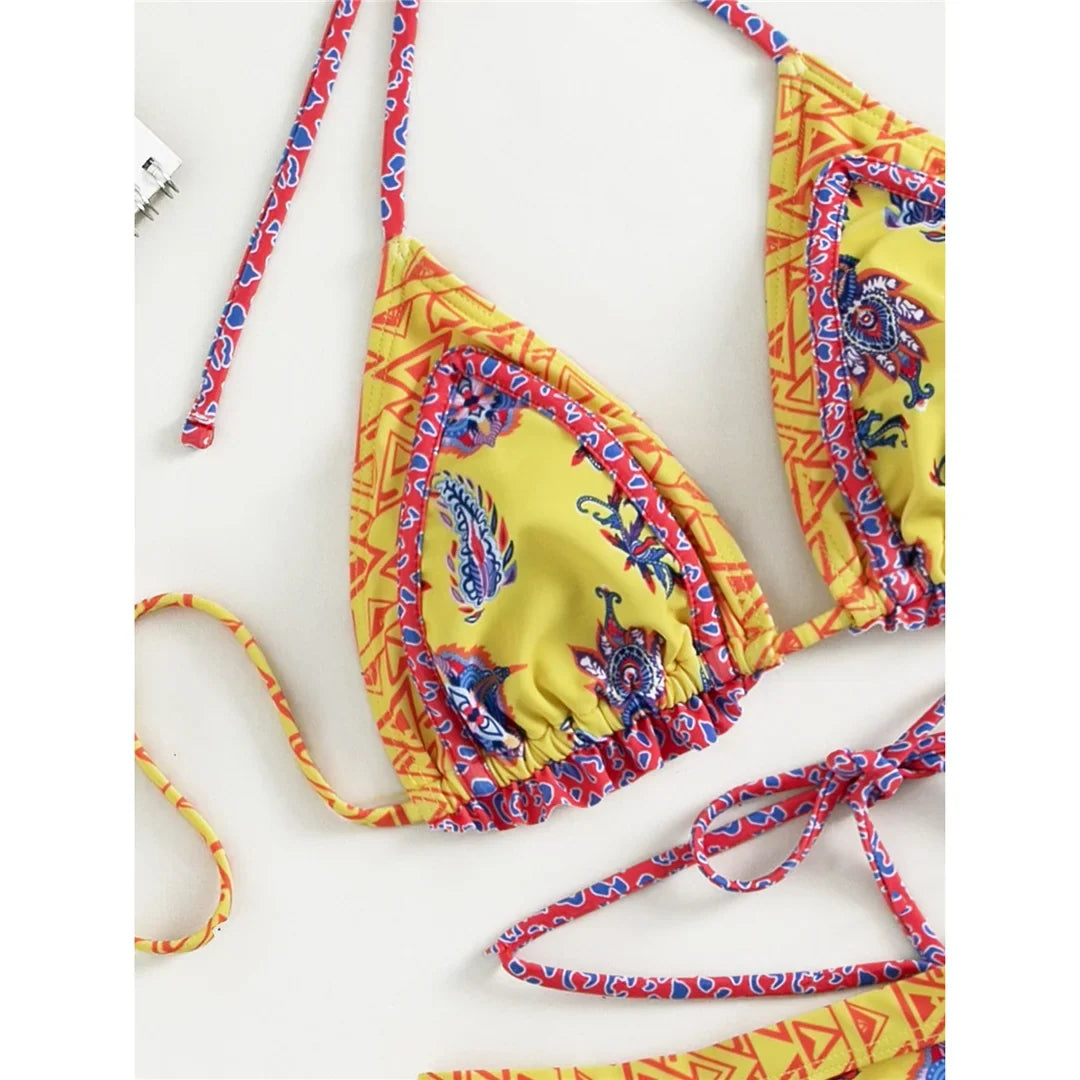 Gros plan sur le haut jaune imprimé paisley bleu et volants roses, bordure à motifs géométriques, vue rapprochée