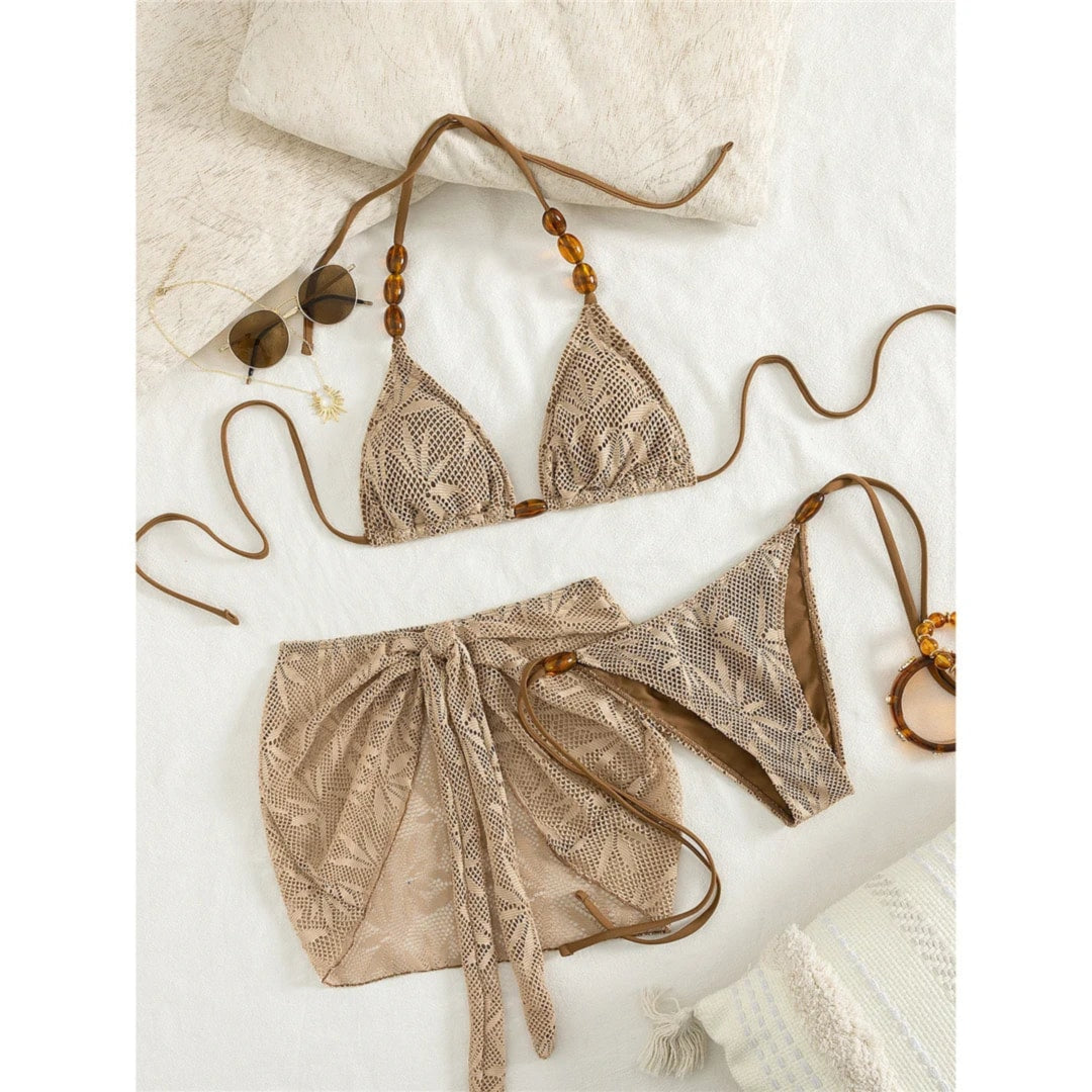 Maillot de bain trois pièces marron café à jupe nouée sur les hanches, posé à plat avec lunettes et lanières perlées
