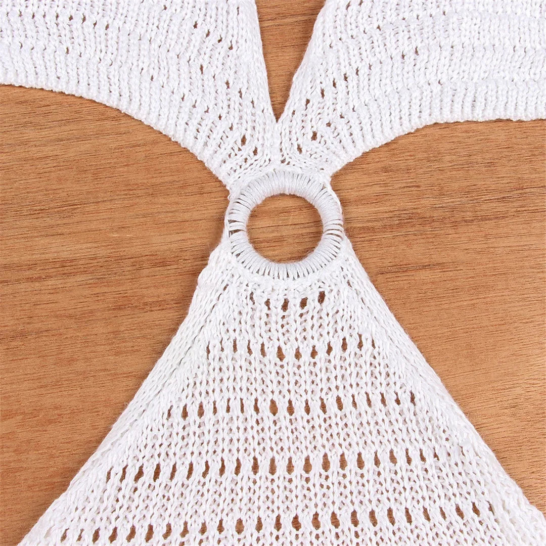 Gros plan sur l'anneau central d'une tunique de plage au crochet blanc, mailles ajourées autour du décolleté V