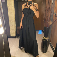 Robe de plage longue ample noire à cordes et dos ouvert, portée en selfie avec cordes nouées au cou