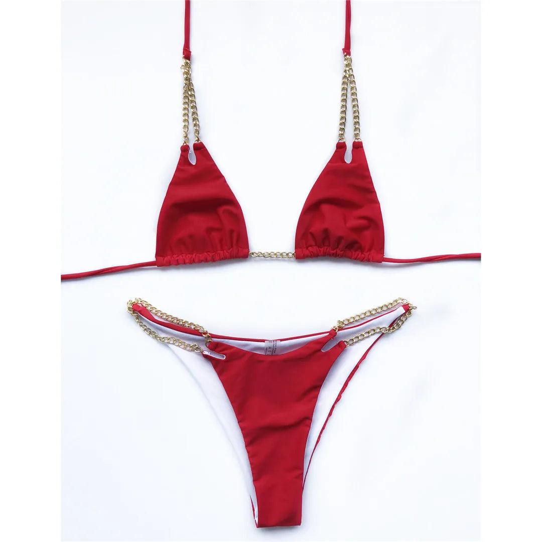 Bikini tour de cou à chaîne métallique rouge posé à plat sur fond blanc, chaînes dorées sur la culotte