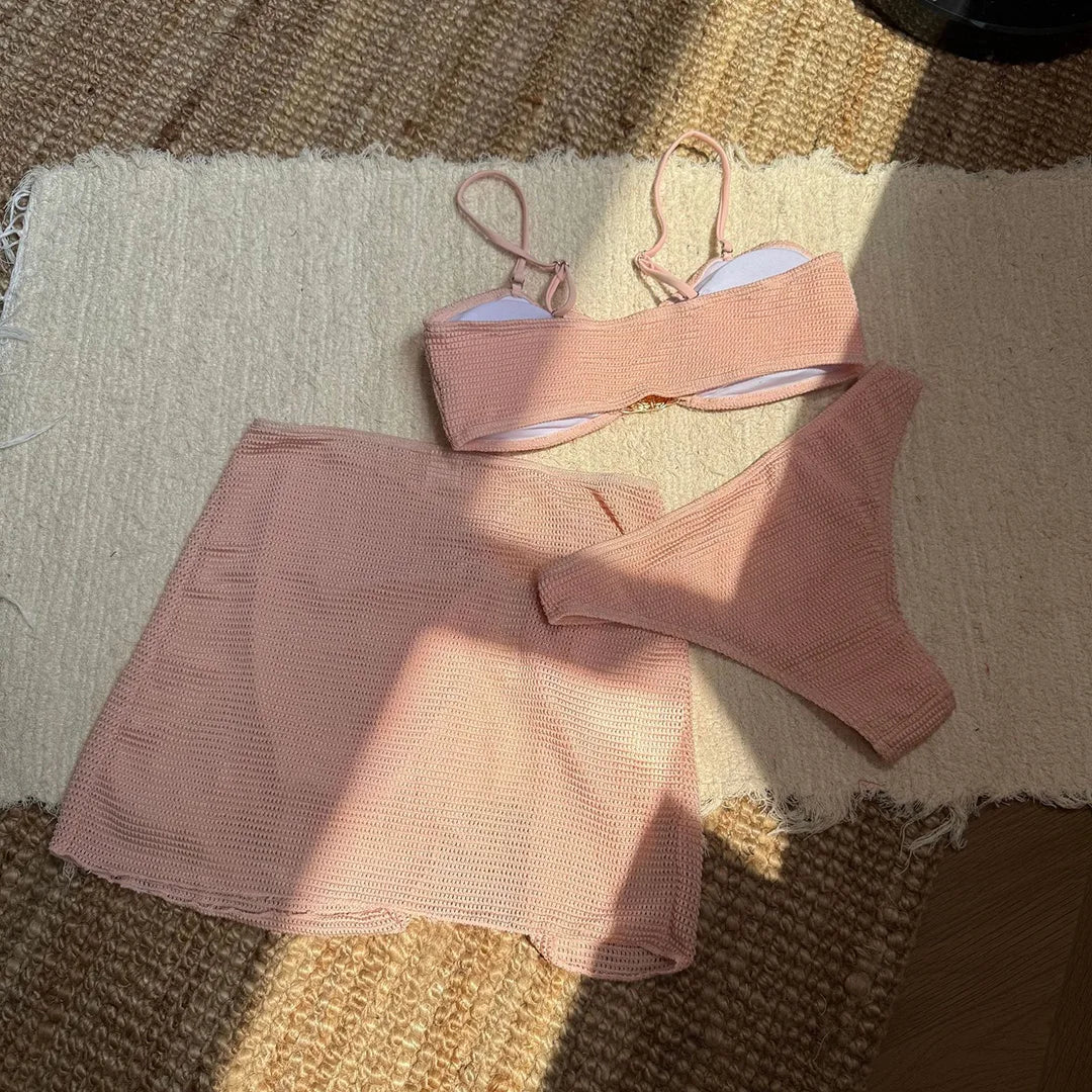 Bandeau rose vu de l’intérieur à plat, doublure blanche visible, bas brésilien et jupe posés à côté