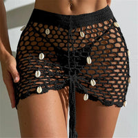 Cache-maillot jupe noire en crochet ajouré à coquillages, nouée par un cordon de serrage sur le devant