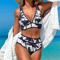 Bikini décolleté en V imprimé cocotiers porté de face avec un kimono blanc sur les épaules, mer bleue en arrière-plan