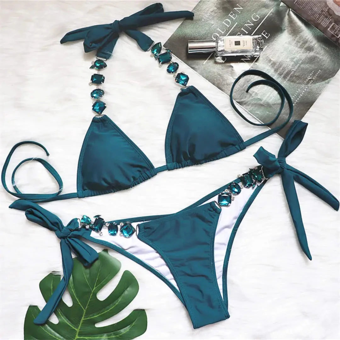 Bikini brésilien à strass effet diamant brillant bleu à plat sur un magazine, bordure de strass sur la culotte