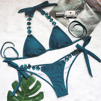 Bikini brésilien à strass effet diamant brillant bleu à plat sur un magazine, bordure de strass sur la culotte