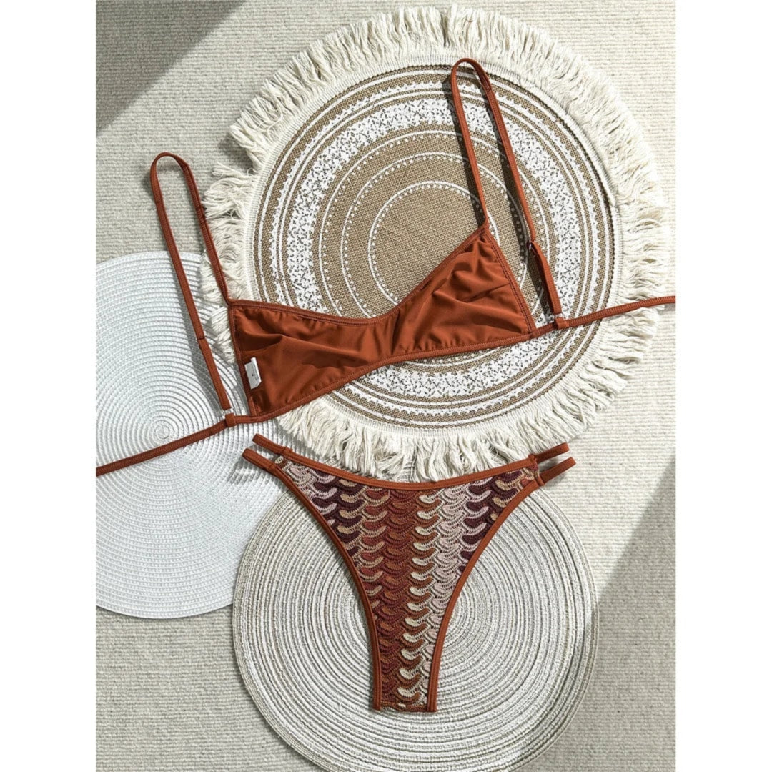 Bikini triangle échancré rouge brique à bretelles fines posé à plat sur des sets de table, bas à double bride