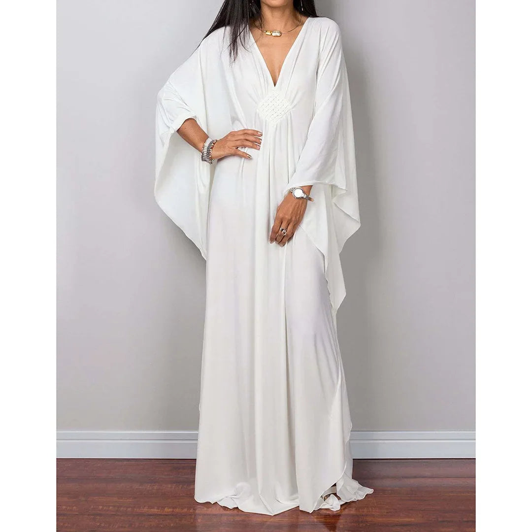 Robe de plage longue kaftan manches chauve-souris blanc portée de face, main sur la hanche et bracelets argentés au poignet