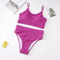 Bikini taille haute côtelé magenta grande taille à plat sur fond blanc, avec un citron et un magazine en décor