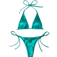 Bikini brésilien satiné vert posé à plat sur fond blanc, haut triangle à bretelles de cou et bas à fins lacets