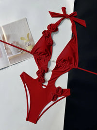 Maillot de bain une pièce fleurs en relief échancré rouge posé à plat, roses rouges sur les bretelles et perles au centre