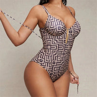 Maillot de bain une pièce col V imprimé marron à motifs géométriques porté de face, cordon latéral tenu par une femme debout