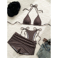 Maillot trois pièces à pois marron café posé à plat sur une surface blanche, avec short fronçé et lacets