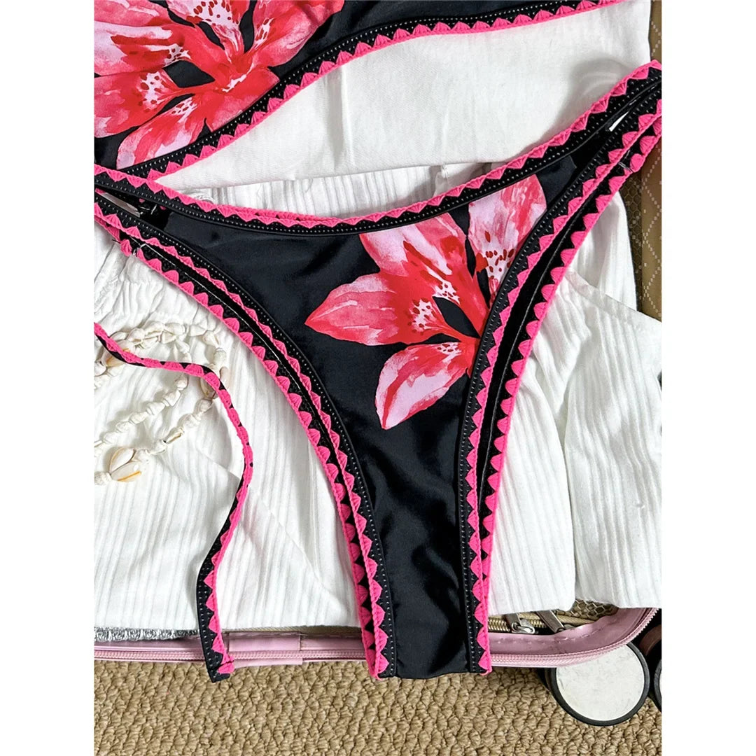 Bikini brésilien triangle imprimé fleuri noir et rose, gros plan sur la culotte et le bord festonné rose