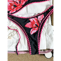 Bikini brésilien triangle imprimé fleuri noir et rose, gros plan sur la culotte et le bord festonné rose