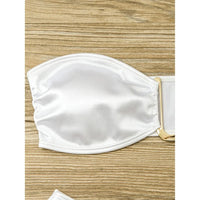 Gros plan sur le haut blanc du bikini bandeau sans armatures, anneau métallique au centre du bandeau