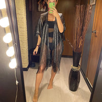 Tunique de plage à franges en maille brillante noire portée de face en selfie miroir, maille transparente sur un maillot noir