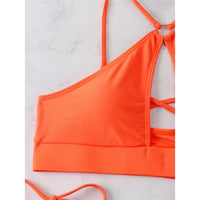 Bikini tour de cou à découpes et lanières orange, gros plan sur le haut à découpe croisée et la bretelle asymétrique