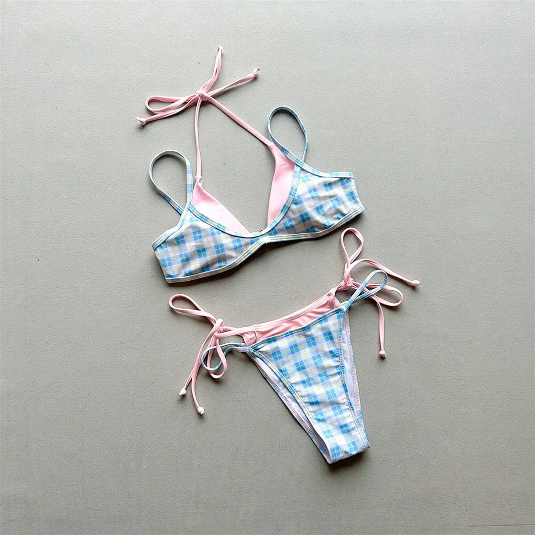 Bikini à carreaux bleu ciel au centre d'un fond gris uni, haut à bretelles fines et bas à liens roses