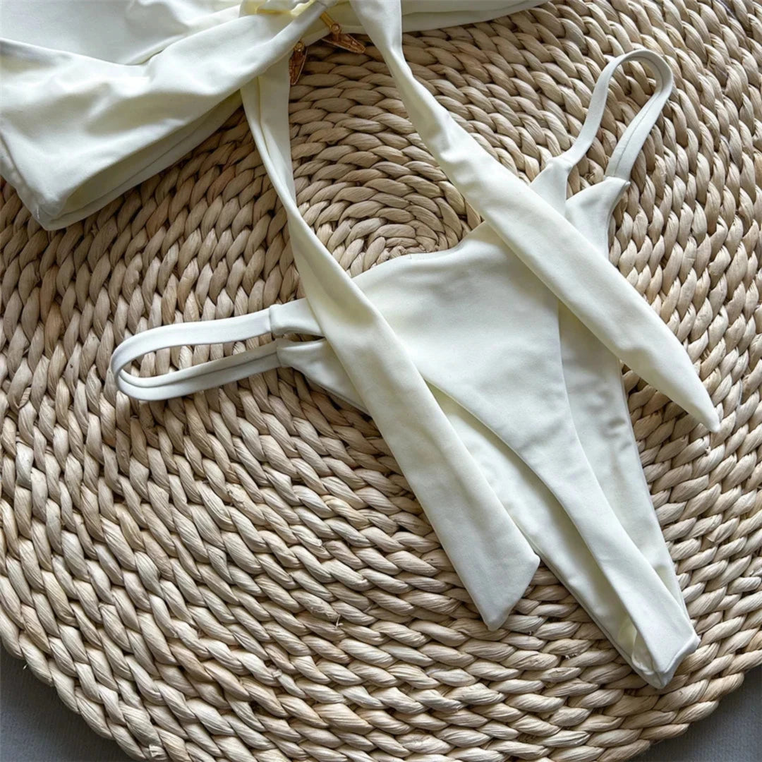 Bikini bandeau string échancré à étoile métallique beige vu de près, lanières fines du slip et bord du haut en gros plan