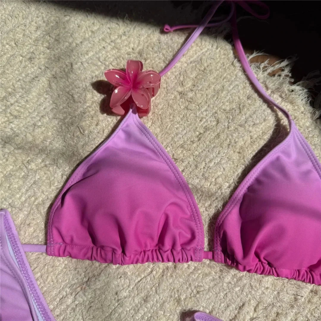 Gros plan sur le haut triangle rose dégradé, fleur rose au col et bonnets froncés en bas de la pièce