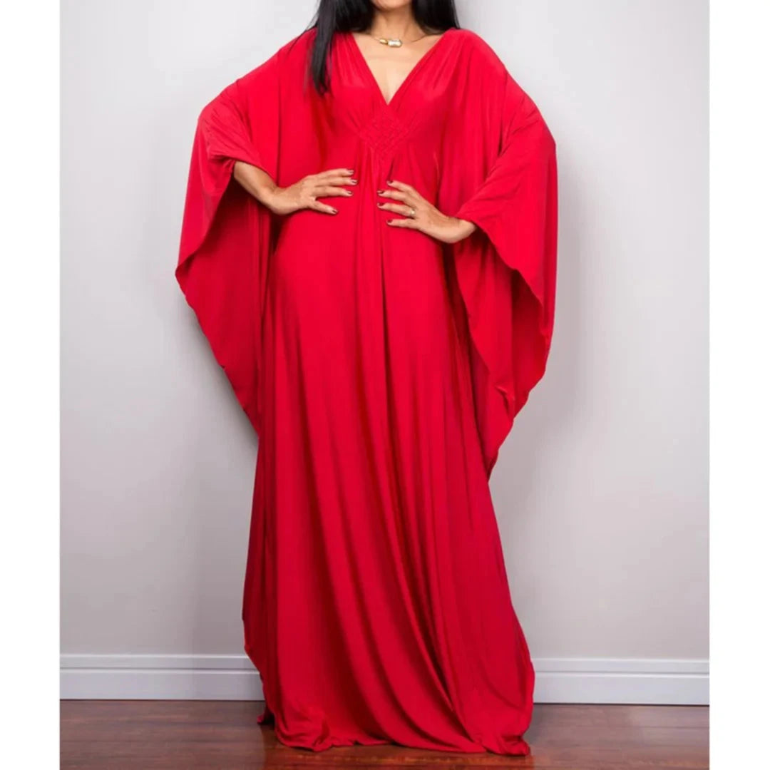Robe de plage longue kaftan manches chauve-souris rouge portée de face, mains sur les hanches et col V tressé au buste