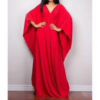Robe de plage longue kaftan manches chauve-souris rouge portée de face, mains sur les hanches et col V tressé au buste